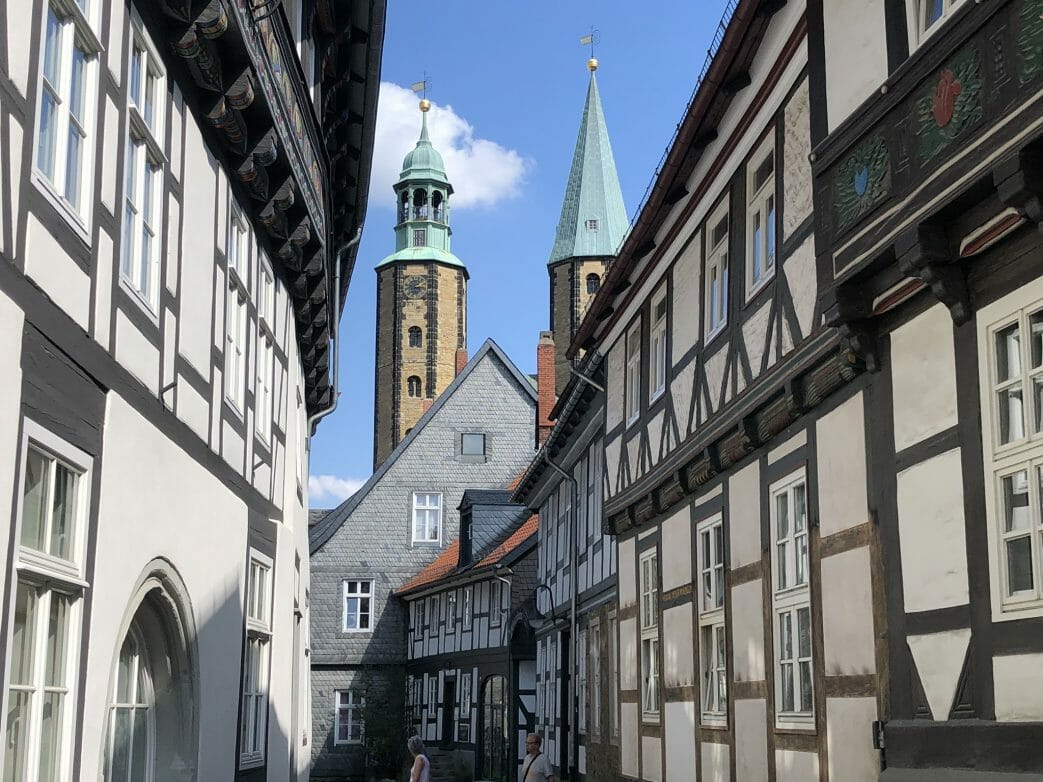 Durch eine verwinkelte Straße geht der Blick zur Marktkirche St. Cosmas und Damian mit beiden unterschiedlichen Türmen.