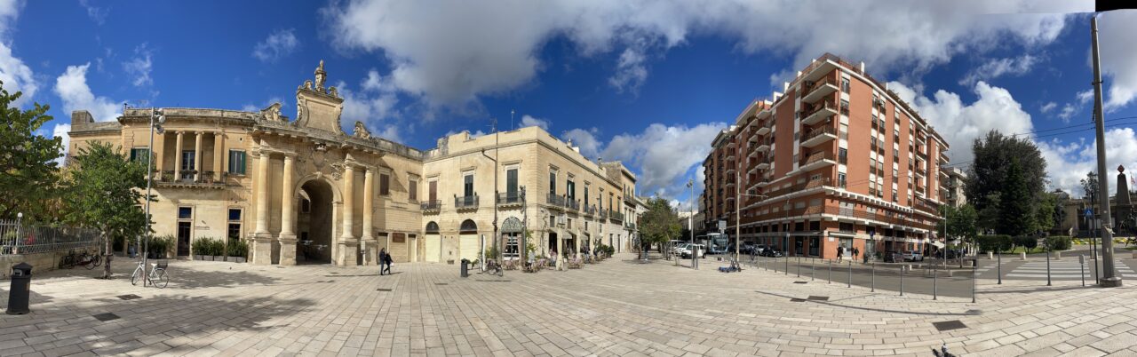 Barockes Stadttor mit hohem, von imposanten Säulen flankiertem Bogen mit Steinreliefs.