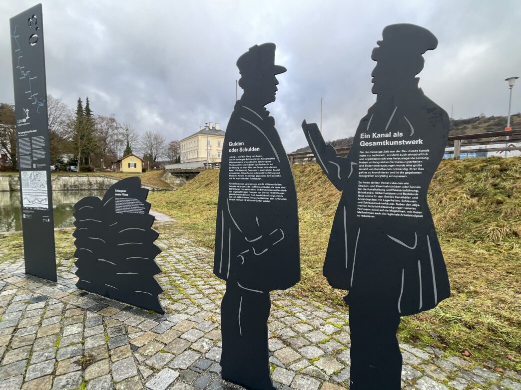 An sechzehn besonderen Standorten entlang des historischen Ludwig-Donau-Main-Kanals zwischen Kelheim und Bamberg geben Infostelen darauf Antwort. Große metallene Figurengruppen an neun dieser Stationen lassen den vergangenen Alltag am Ludwigkanal lebendig werden. Mittels QR-Code abrufbare Hörgeschichten geben dabei Einblick in die Geschichte der Wasserstraße, ihrer Planer und Erbauer sowie der Menschen, die an ihrem Ufer lebten.