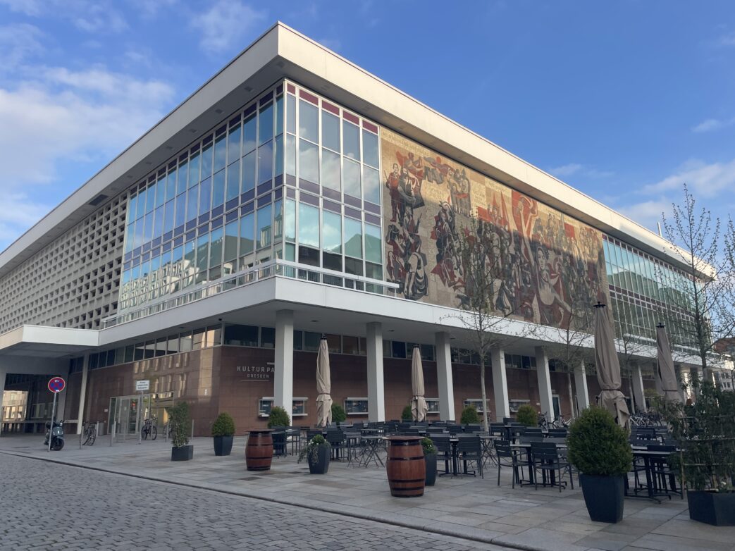 Dresden Weber roten Fahne ein.[5] Es ist seit 2001 als Kulturdenkmal ausgewiesen. 1968 wurde Gerhard Bondzin mit der Erarbeitung der Entwürfe beauftragt. Das Wandbild wurde bis 1969 durch eine Arbeitsgemeinschaft der Hochschule für Bildende Künste Dresden umgesetzt. Der Arbeitstitel lautete: „1849 – 1969: 120 Jahre Kampf der revolutionären Kräfte der Stadt für Fortschritt und Sozialismus“.