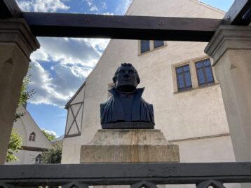 Übersicht mit KI Die historische Martin-Luther-Büste vor Luthers Geburtshaus in der Lutherstadt Eisleben stammt aus dem Jahr 1817 und wurde im Oktober 2025 nach einer umfassenden Restaurierung feierlich in den Pergolagarten zurückgebracht.